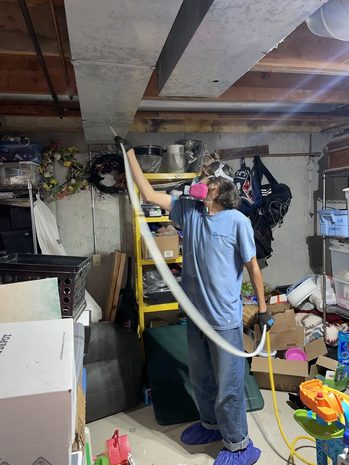 Technician Cleaning Basement Hose provided by Air Pro UT.